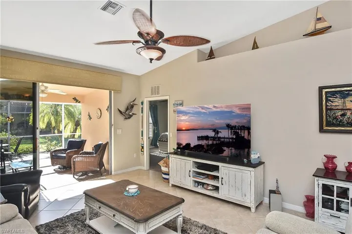 Living room with light tile patterned floors and vaulted ceiling