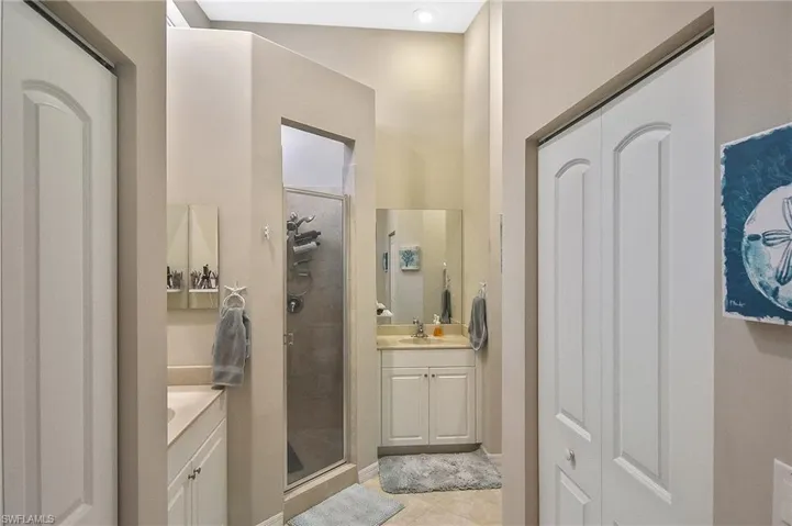 Bathroom with tile patterned floors, vanity, and an enclosed shower