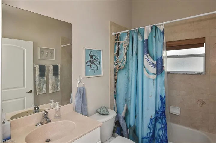 Full bathroom with vanity, toilet, and shower / bath combo with shower curtain