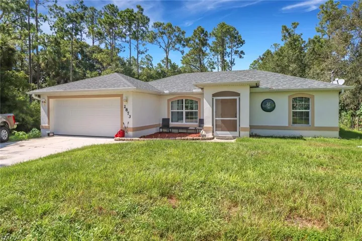Ranch-style home featuring a front lawn and a garage