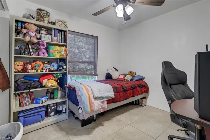 Bedroom with ceiling fan and light tile patterned floors