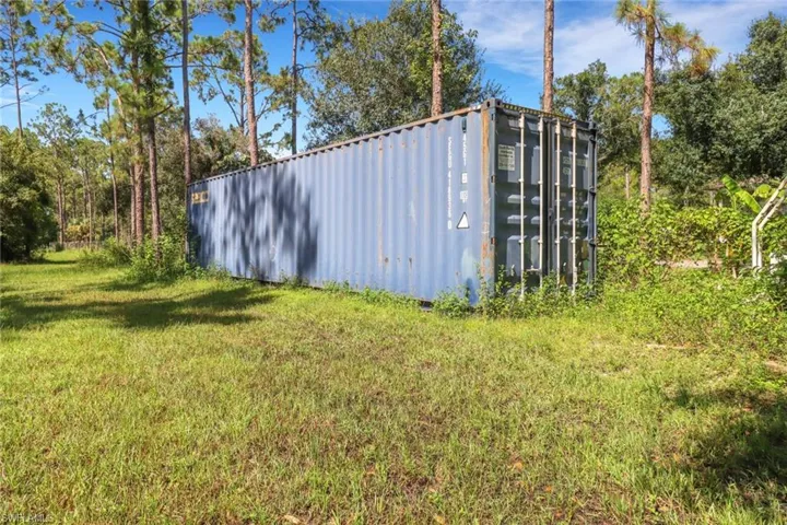 View of outdoor storage structure with a lawn