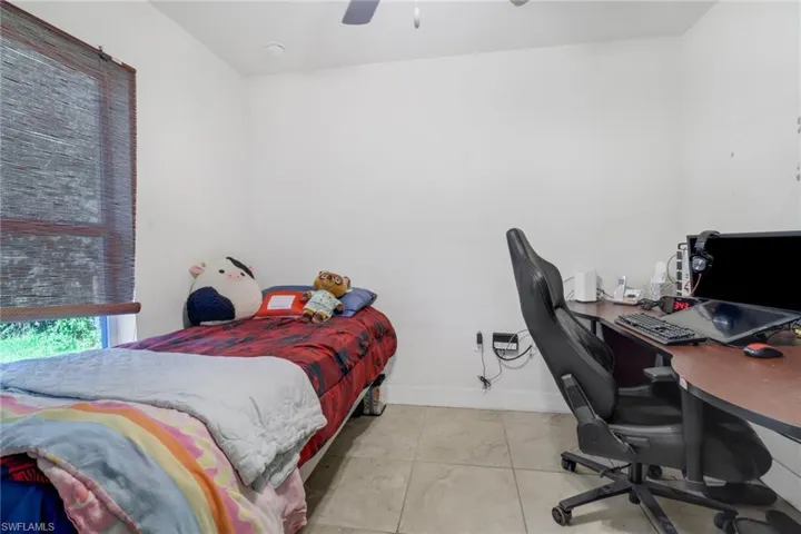 Bedroom with ceiling fan and light tile patterned floors