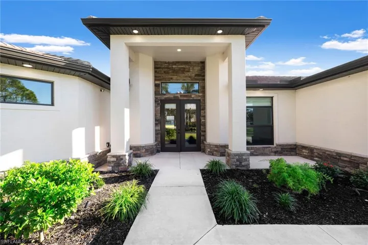 Grand Covered Front Entrance with Decorative Stone Work and Lighting