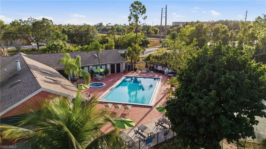 Expansive rectangular swimming pool with integrated spa, surrounded by a brick-paved deck