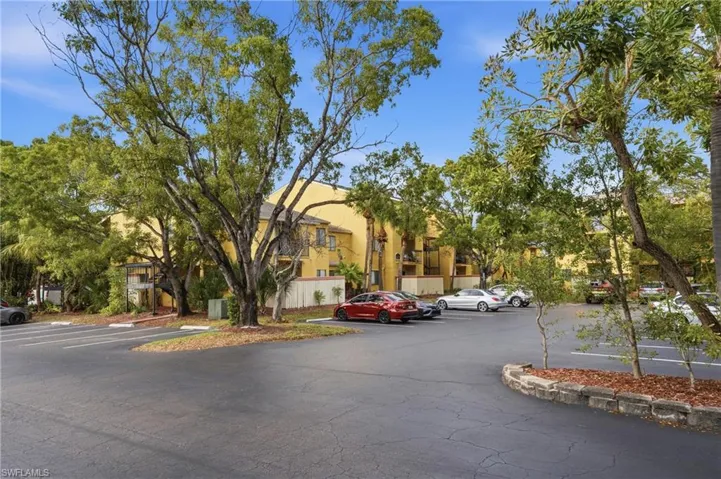 View of apartment building / complex with uncovered parking