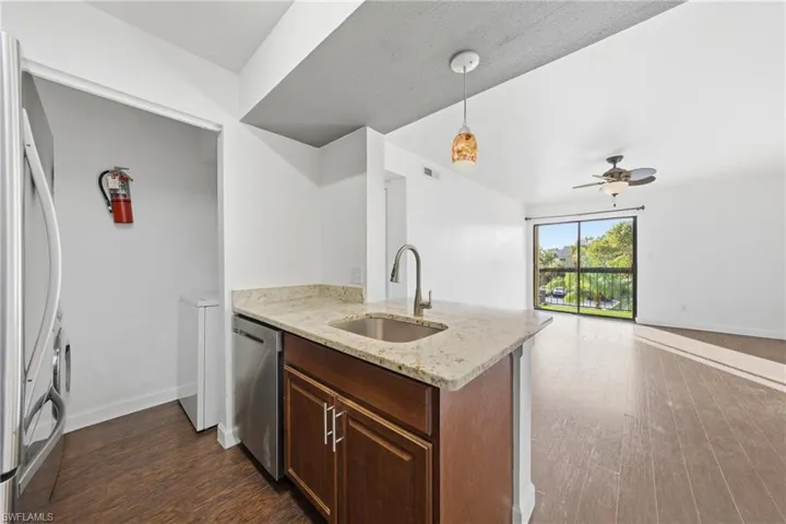 Kitchen island with granite countertop, undermount sink, and stainless steel dishwasher