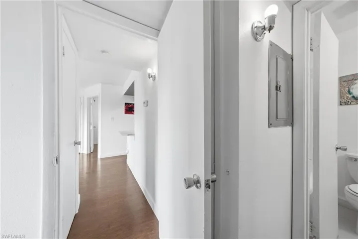 Hallway featuring wood-finish flooring, white walls, and recessed lighting