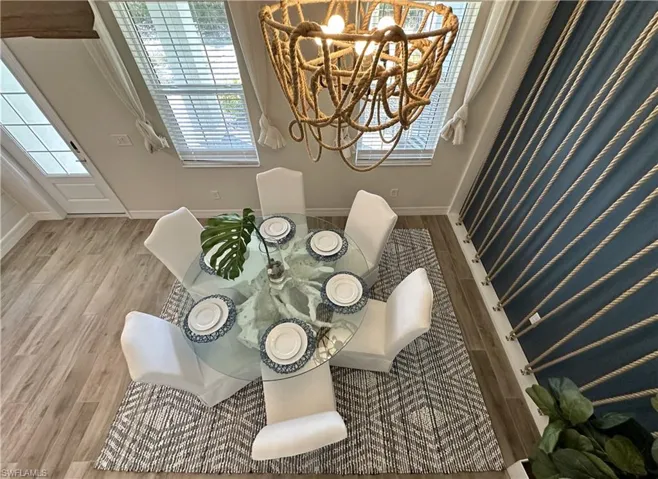 Dining space with wood finished floors and a chandelier
