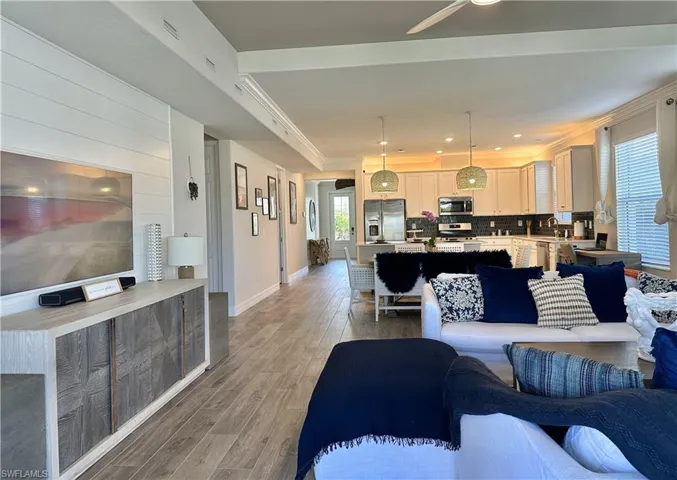 Living room featuring light wood-type flooring, crown molding, recessed lighting, and ceiling fan
