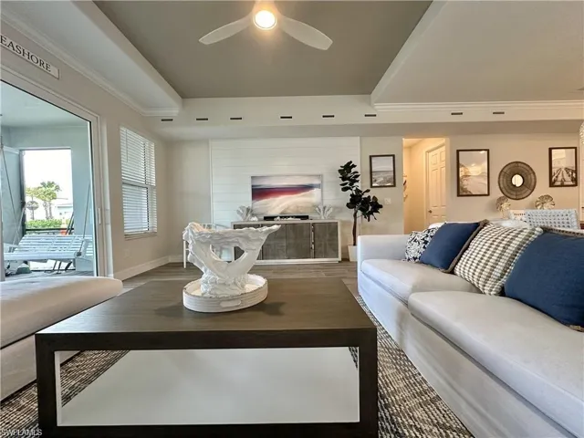 Living area with wood finished floors and ornamental molding
