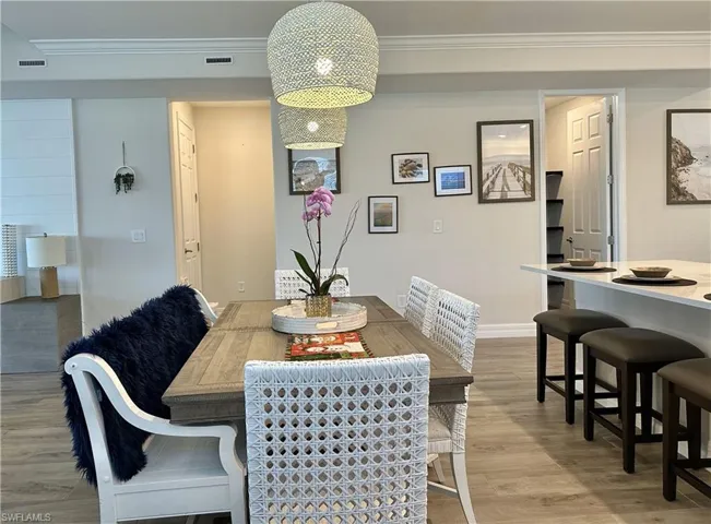 Dining space featuring ornamental molding and light wood-type flooring