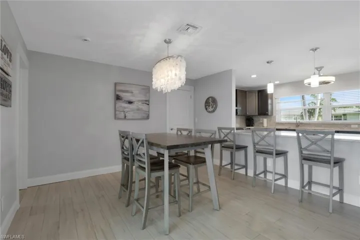 Dining space with a chandelier, light wood-style floors, and recessed lighting