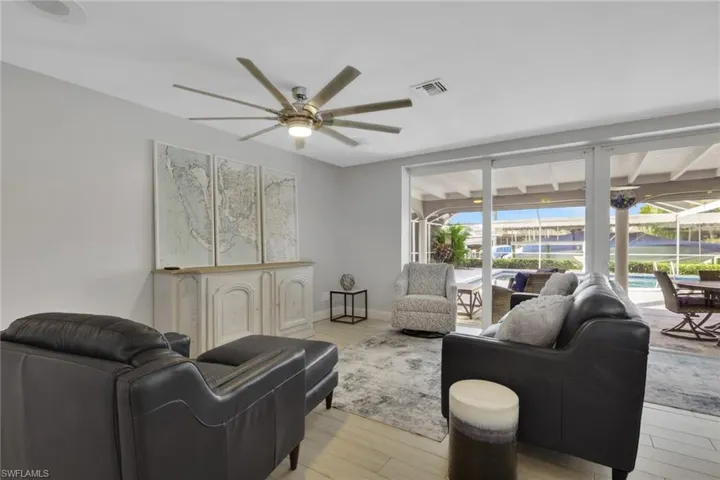 Living area with a sunroom, ceiling fan, and wood finished floors