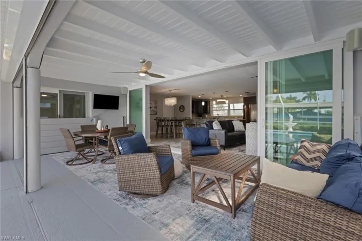 View of patio / terrace with an outdoor living space, ceiling fan, outdoor dining space, and a bar