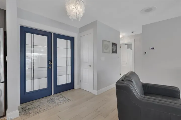 Entryway featuring light wood-style flooring, a chandelier, and french doors