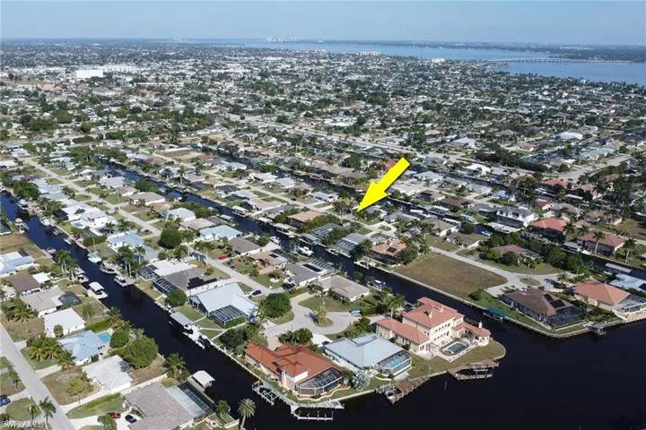 Aerial overview of property's location featuring a large body of water and nearby suburban area