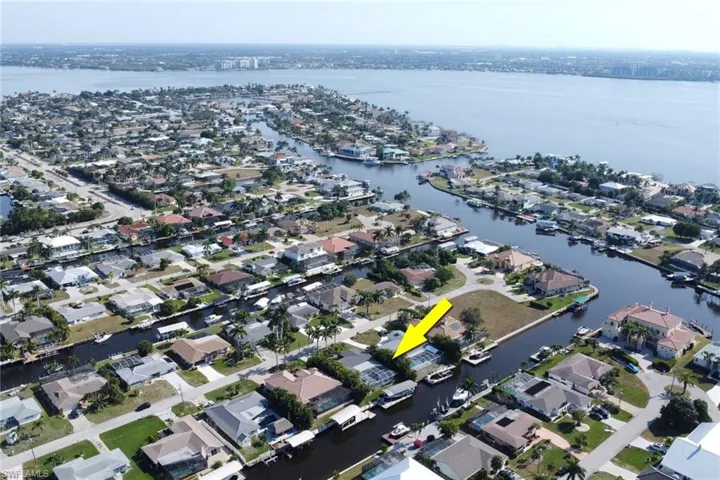 Aerial view of property and surrounding area featuring nearby suburban area