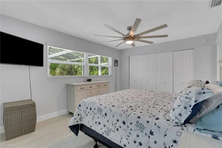 Bedroom with light wood-style floors, a closet, and a ceiling fan
