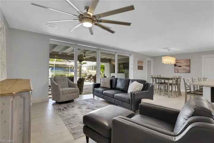 Living room with light wood-type flooring, a chandelier, and a ceiling fan