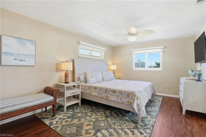 Bedroom featuring dark wood finished floors and a ceiling fan - Virtually Edited Image
