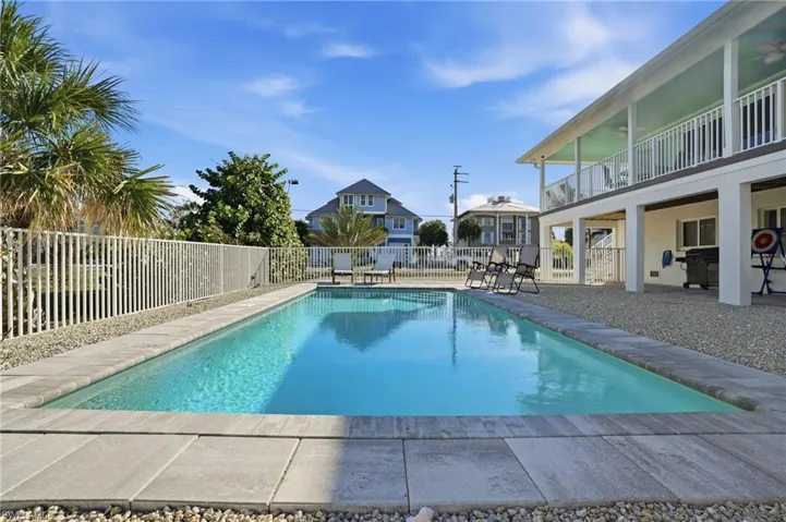 View of swimming pool featuring a patio area and a fenced backyard - Virtually Edited Image
