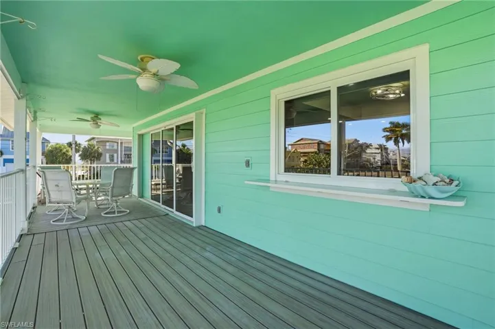 Wooden terrace with outdoor dining space and ceiling fan - Virtually Edited Image