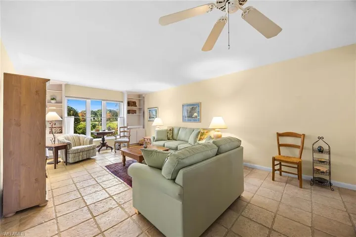 Living room with stone tile floors and built in shelves