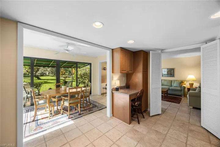 Kitchen featuring brown cabinets, recessed lighting, ceiling fan, and a sunroom