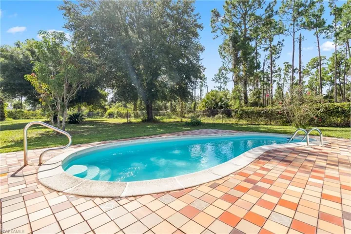 View of swimming pool with a lawn and a patio