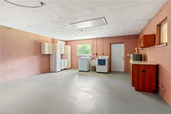 Basement with sink, a textured ceiling, and washer and dryer