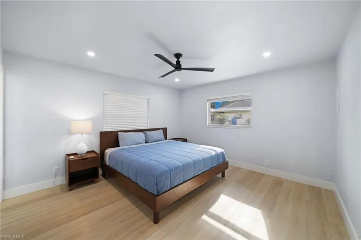 Guest House Bedroom with ceiling fan and light wood-type flooring
