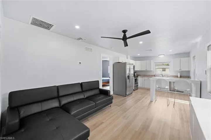 Guest House Living room with light wood-type flooring, ceiling fan, and sink
