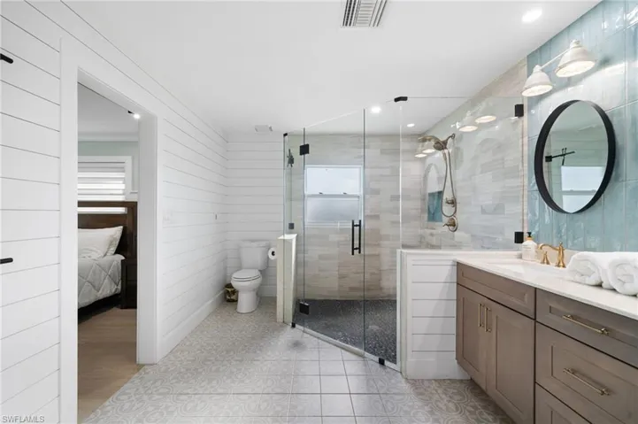 Bathroom featuring vanity, toilet, and a shower with shower door