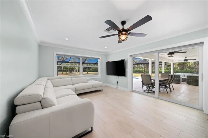 Living room with crown molding, ceiling fan