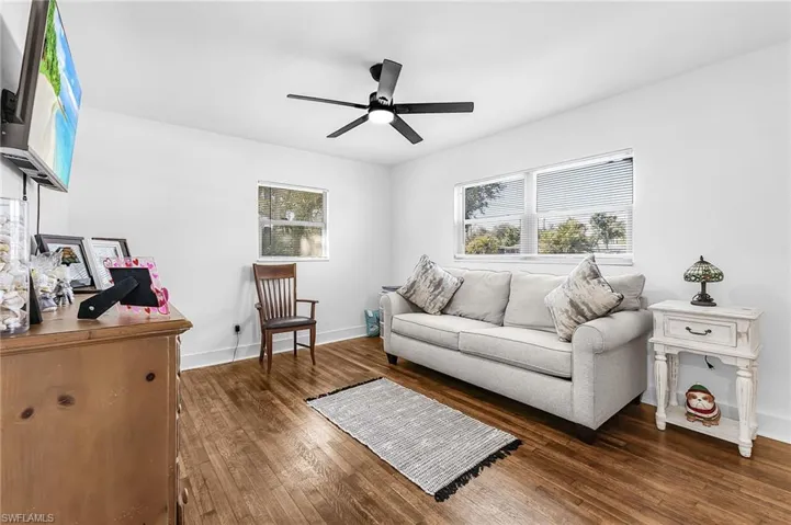 Living room featuring dark wood finished floors and ceiling fan