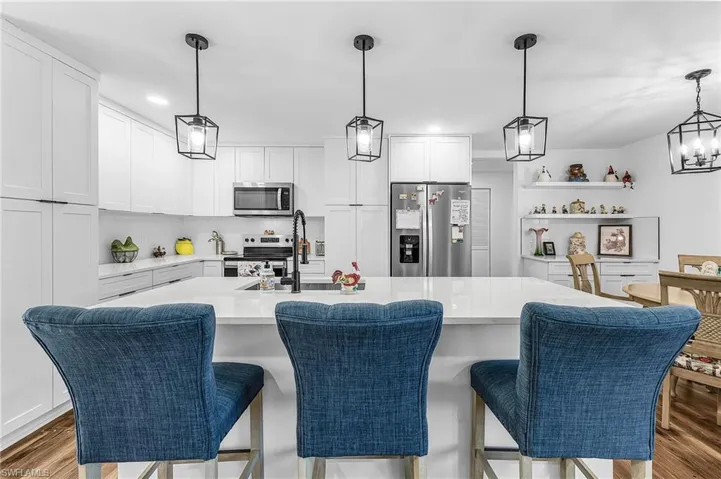 Kitchen featuring appliances with stainless steel finishes, hanging light fixtures, white cabinets, dark wood finished floors, and recessed lighting