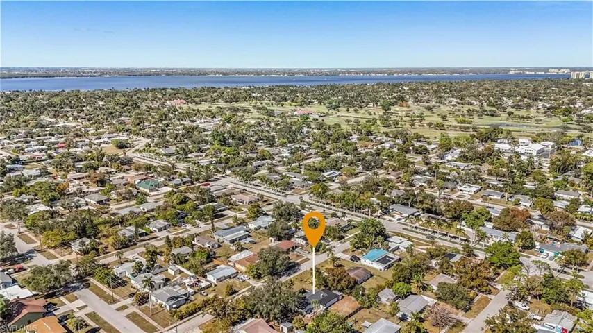 Aerial view of property and surrounding area with nearby suburban area and a nearby body of water