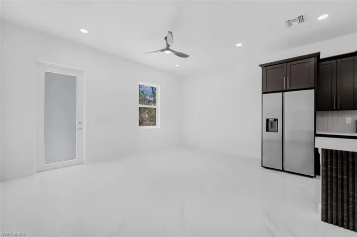 Unfurnished living room featuring recessed lighting, ceiling fan, and light marble finish flooring