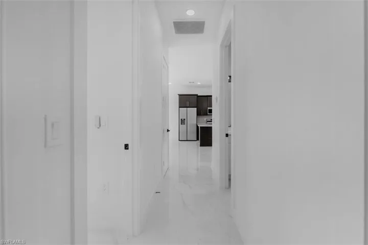 Hallway with recessed lighting and light marble finish floors