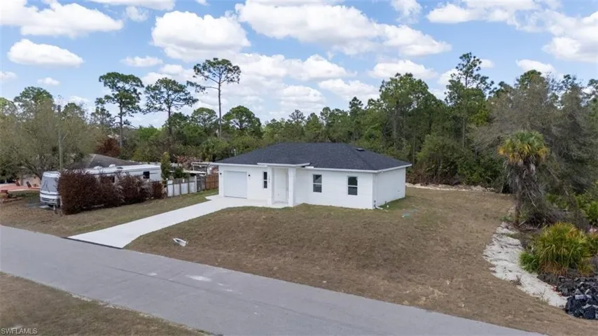 Ranch-style home with a front lawn, driveway, and a garage