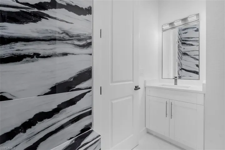 Bathroom with vanity and light marble finish floors
