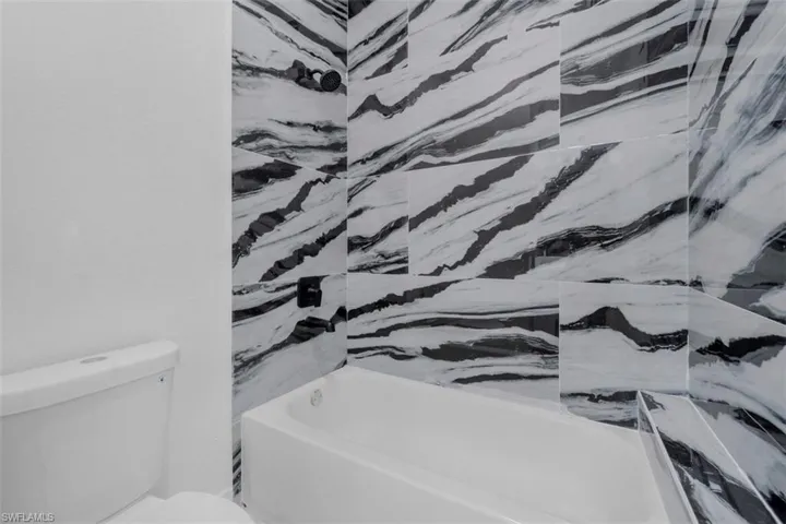 Bathroom with toilet and bathing tub / shower combination