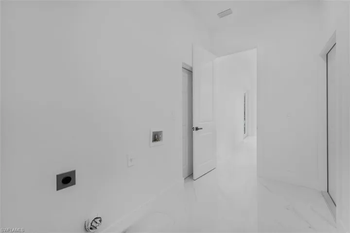 Laundry area with washer hookup, electric dryer hookup, and light marble finish flooring