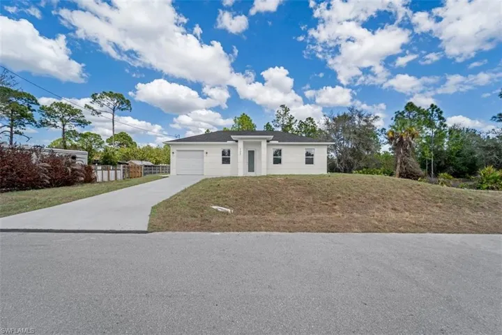 Single story home featuring concrete driveway and an attached garage
