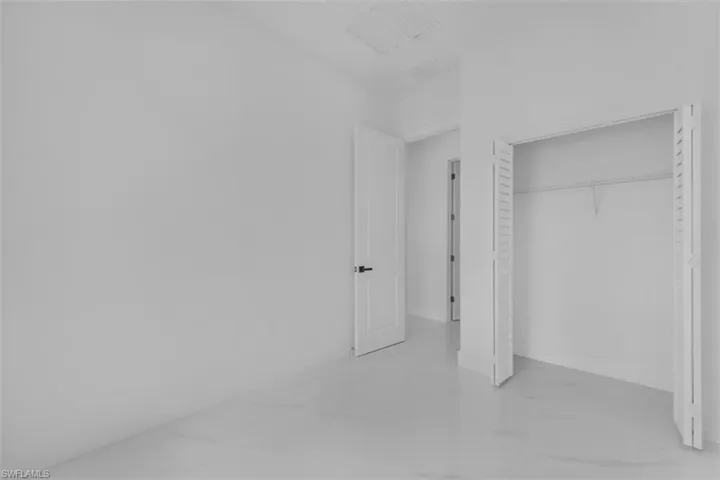 Unfurnished bedroom featuring a closet and light marble finish flooring
