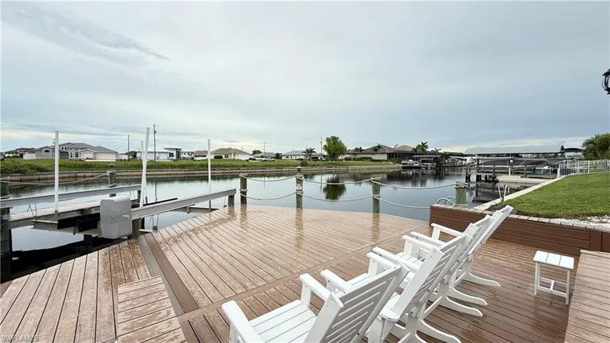 Dock featuring a water view, boat lift, and a residential view
