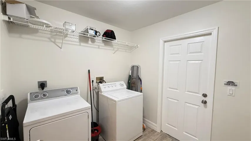 Laundry area with washer and dryer and light wood-style floors