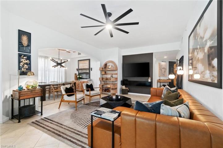 Living area opening up into the dining area highlighted by a decorative ceiling and designer lighting fixture.