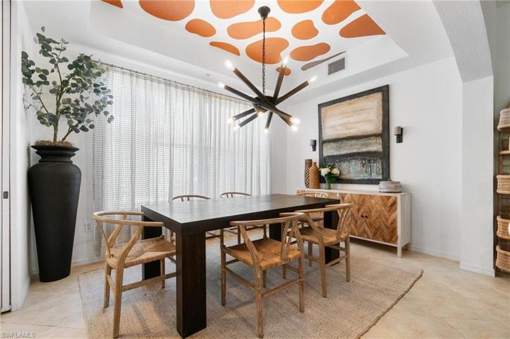 Dining area with seating for 6 is adorned by ceiling accents and designer lighting fixture creating the ideal dining space.
